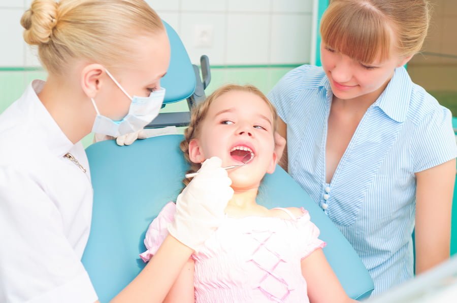 female dentists examines a child