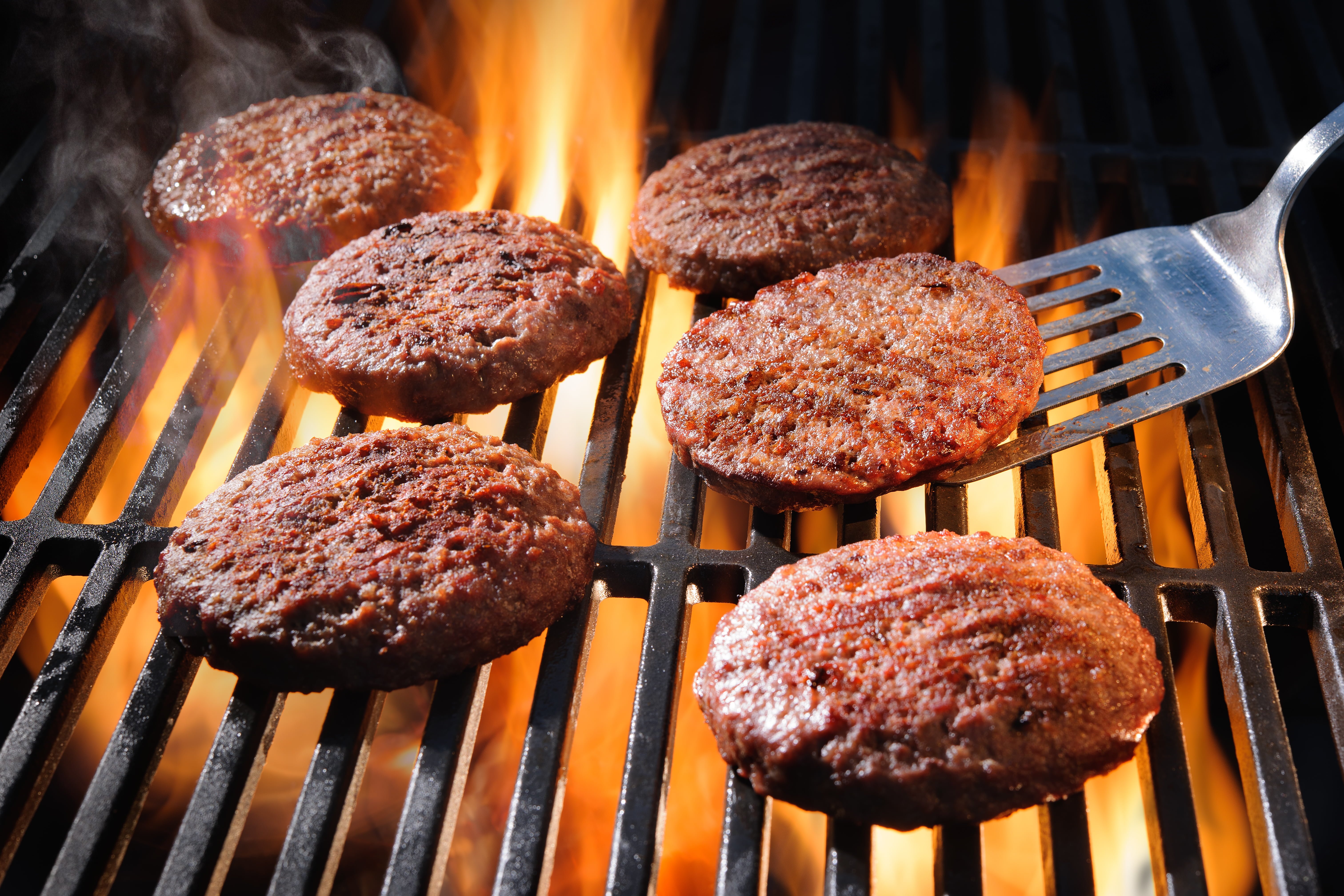 Beef hamburger patties sizzling on the barbecue - AskDrManny