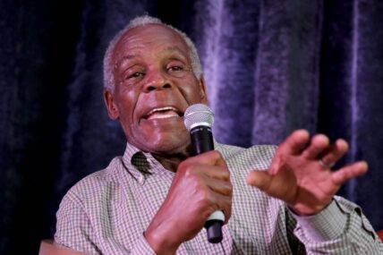 Actor Danny Glover speaking into a microphone.