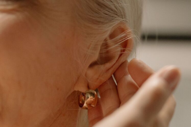 A woman cupping her ear.